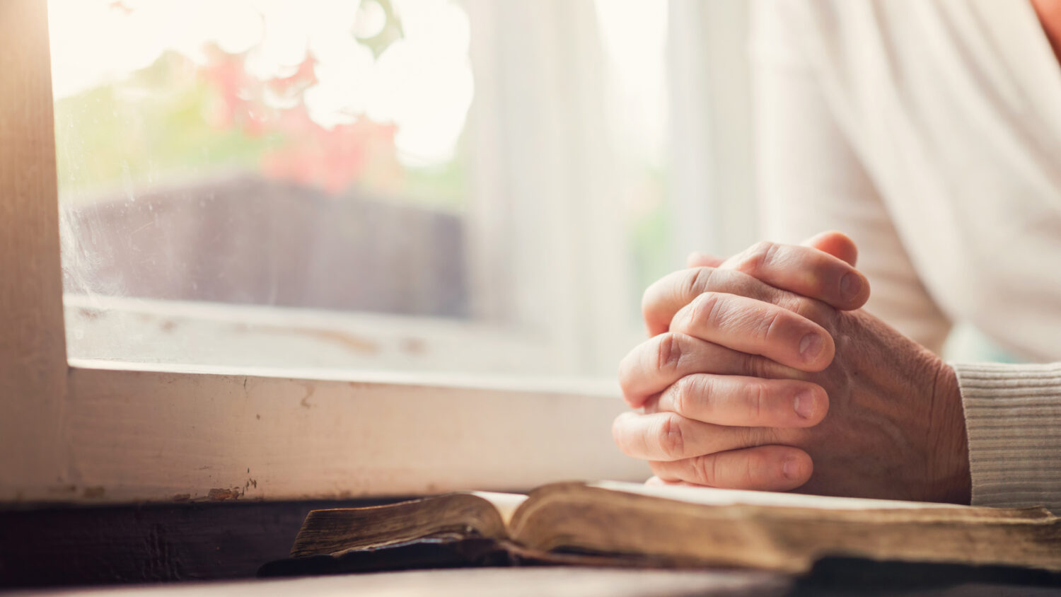 Knäppta händer på en bibel